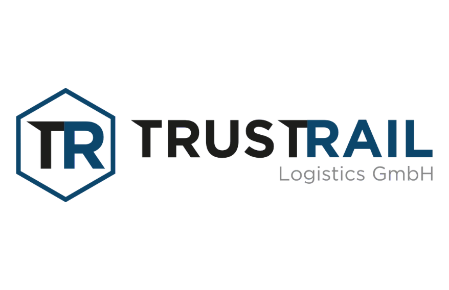 Logo von „TrustRail Logistics GmbH": Ein sechseckiges blaues Rahmensymbol mit den Initialen „TR" links, gefolgt vom Firmennamen „TRUSTRAIL" – „TRUST" in Schwarz, „RAIL" in Dunkelblau – und dem Zusatz „Logistics GmbH" in Grau. Transparenter Hintergrund.